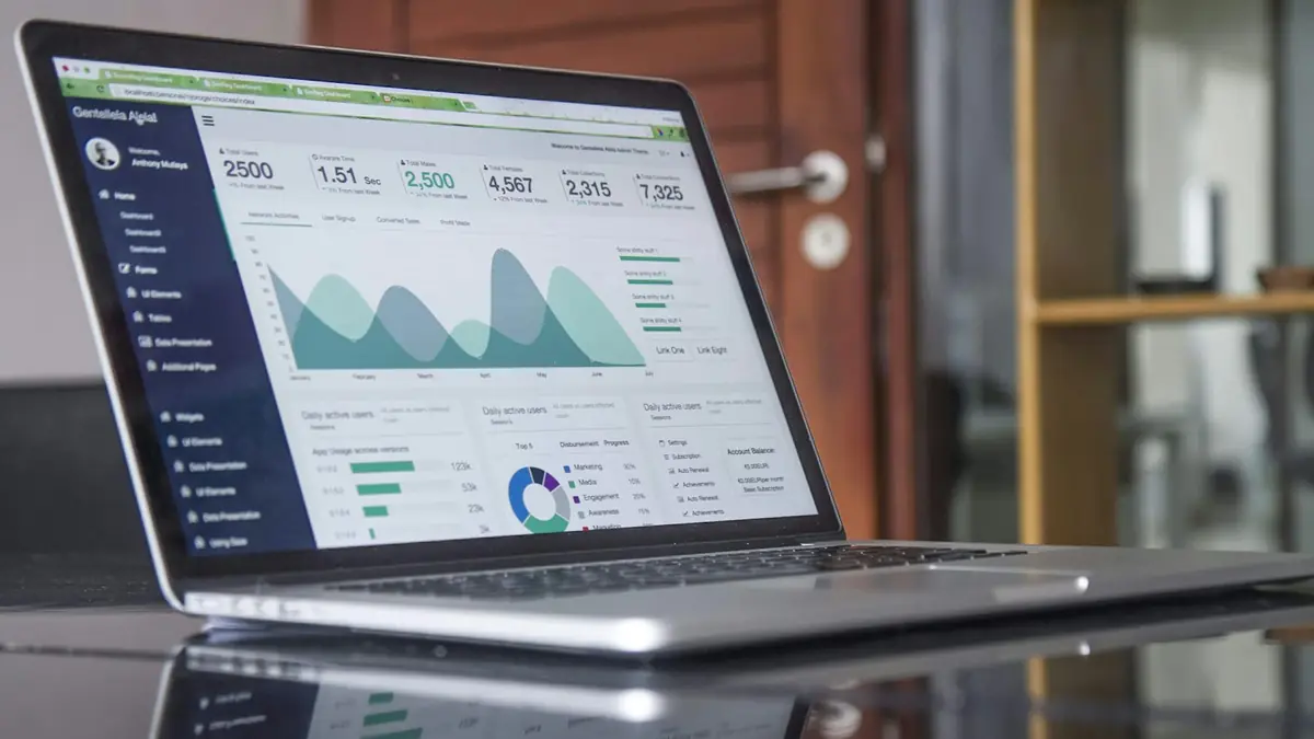 Portátil sobre una mesa mostrando un tablero de métricas de marketing