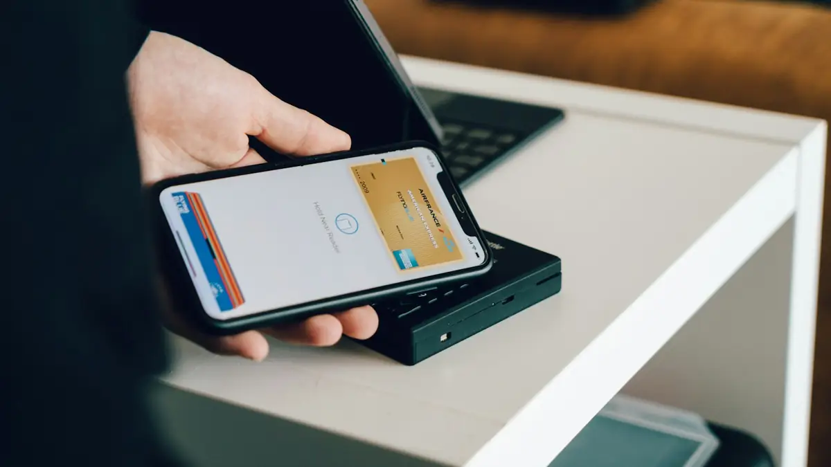 Persona pagando con su teléfono en un lector de tarjetas