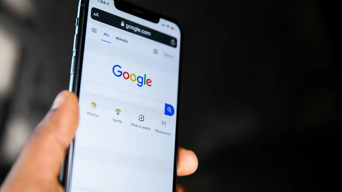 Mano sosteniendo un teléfono con la página de Google abierta