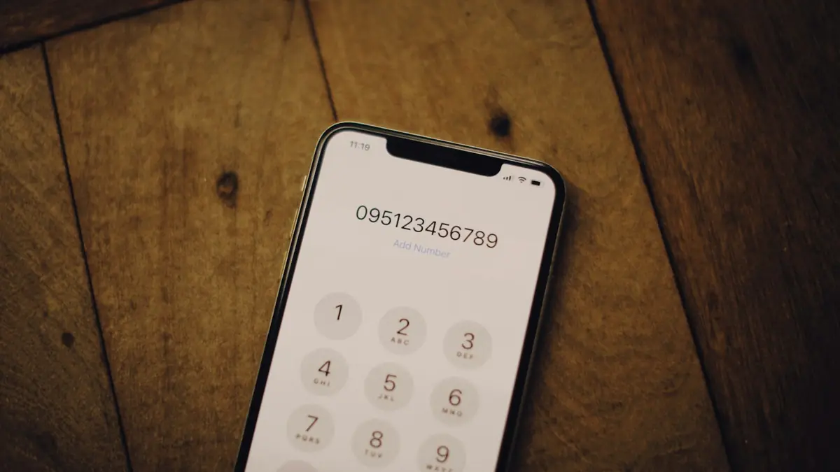 Celular con el teclado de llamadas abierto sobre una mesa de madera