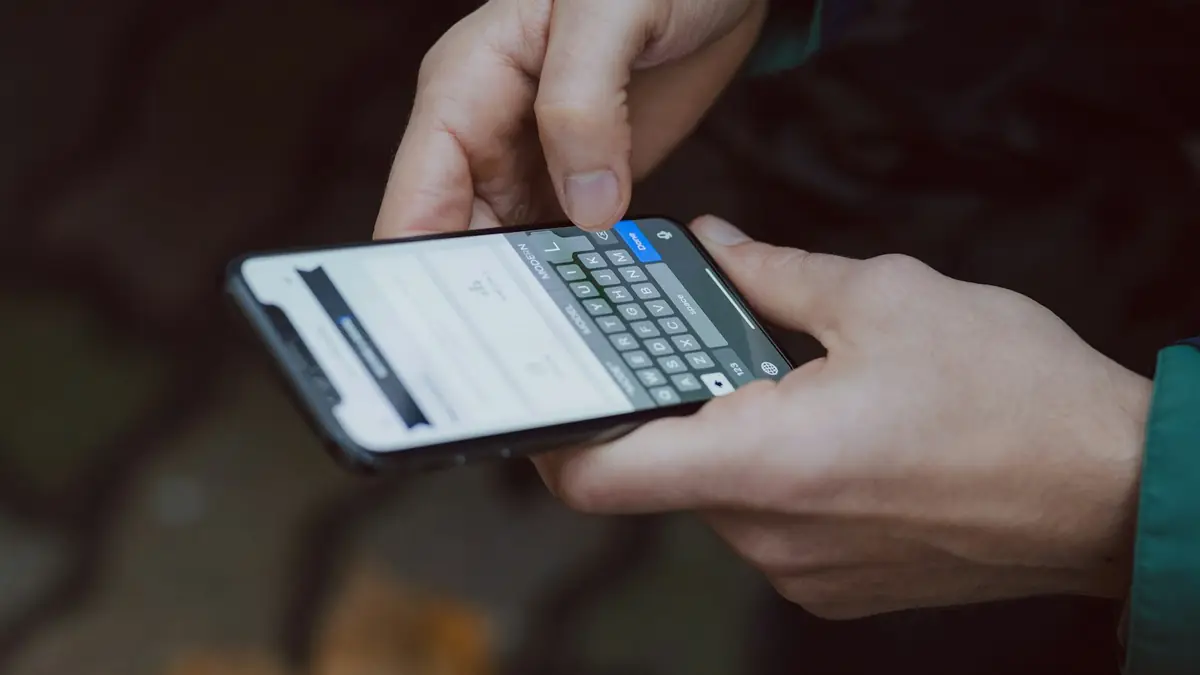 Mano sosteniendo un teléfono inteligente con una aplicación de mensajería