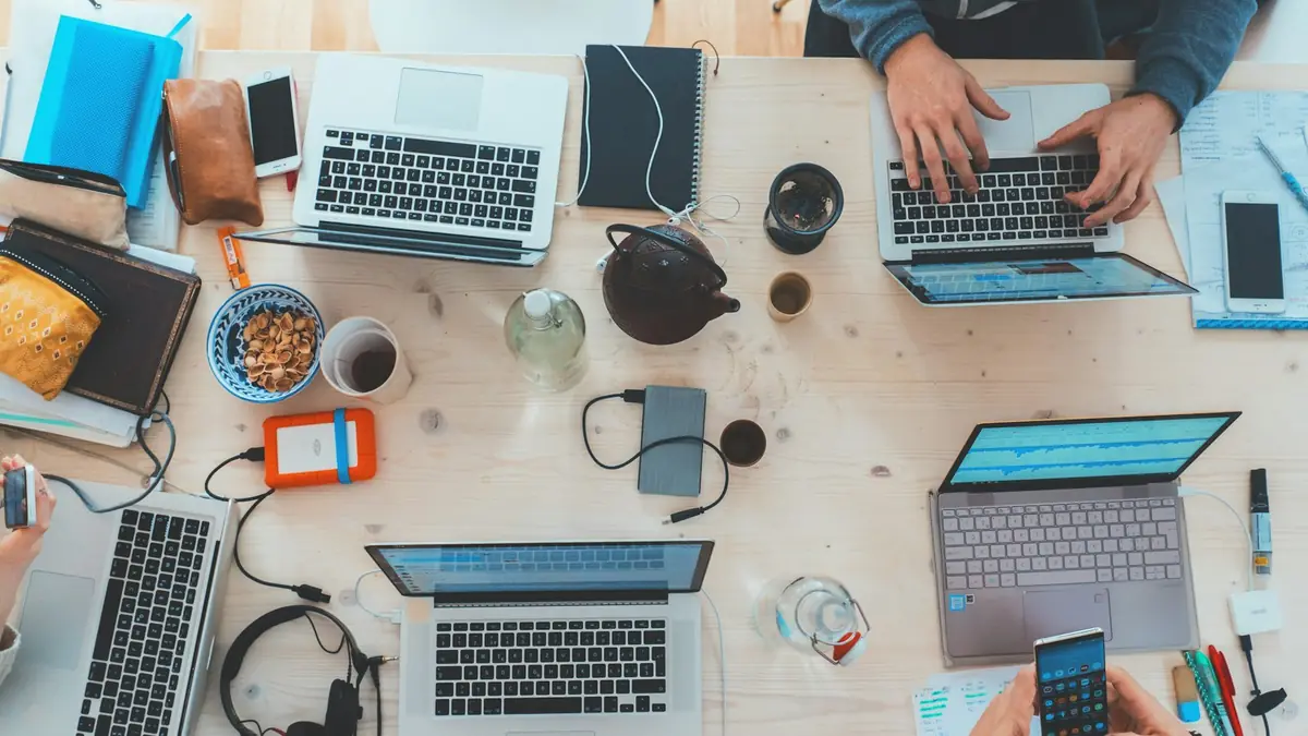 Equipo de trabajo colaborando alrededor de varios portátiles