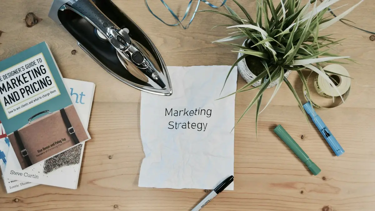 Libros de marketing y una hoja con la palabra estrategia sobre un escritorio